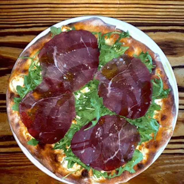 Pizza con stracchino breosala e ruchetta.