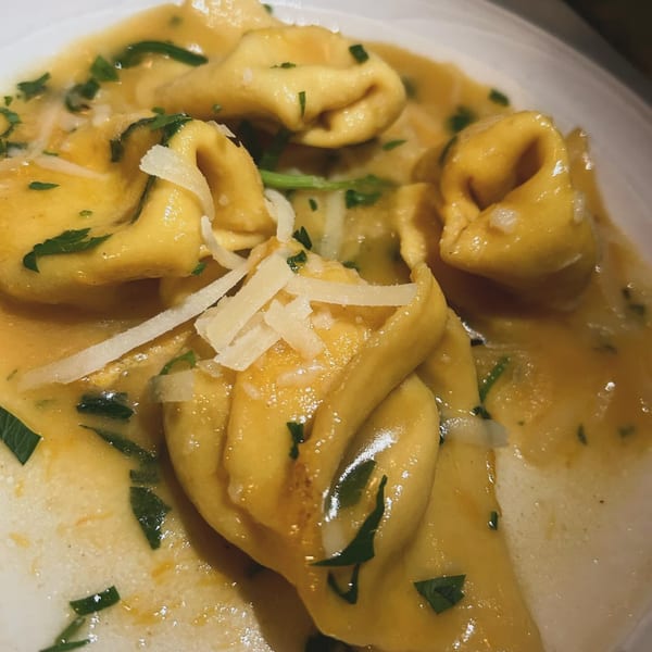 Close-up of Celeste Restaurant's tortellini pasta in a creamy sauce, garnished with fresh parsley and parmesan.